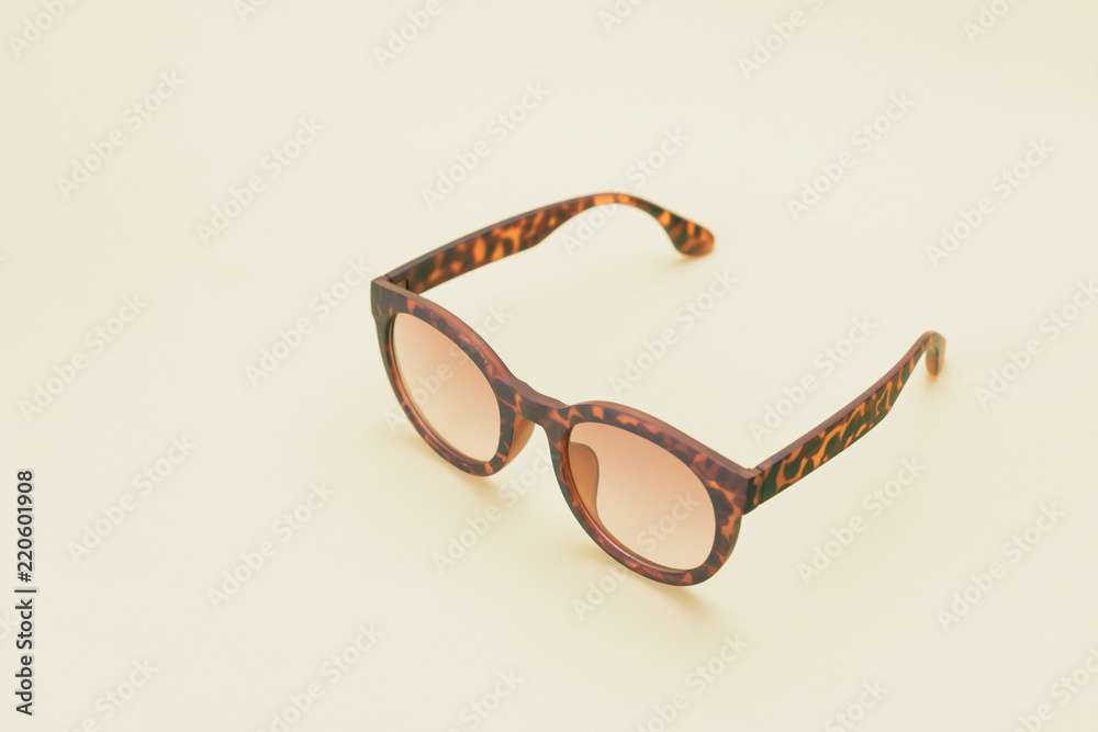 A pair of tortoises shell style fashion glasses isolated on light color background. A pair of tortoises shell style fashion glasses isolated on light color background.