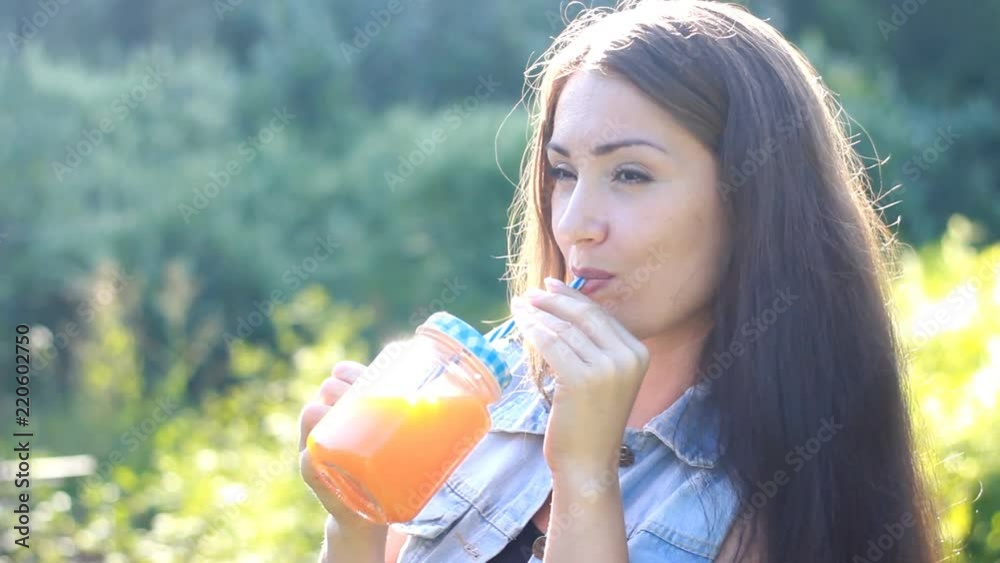 Woman drinks smoothies or orange fresh outdoors. Woman drinks smoothies or orange fresh outdoors.