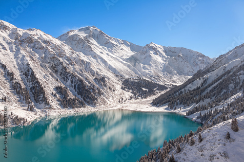 Satpayev peak (4317 m) and emerald Big Almaty lake at winter season. Tian Shan mountains, Kazakhstan.