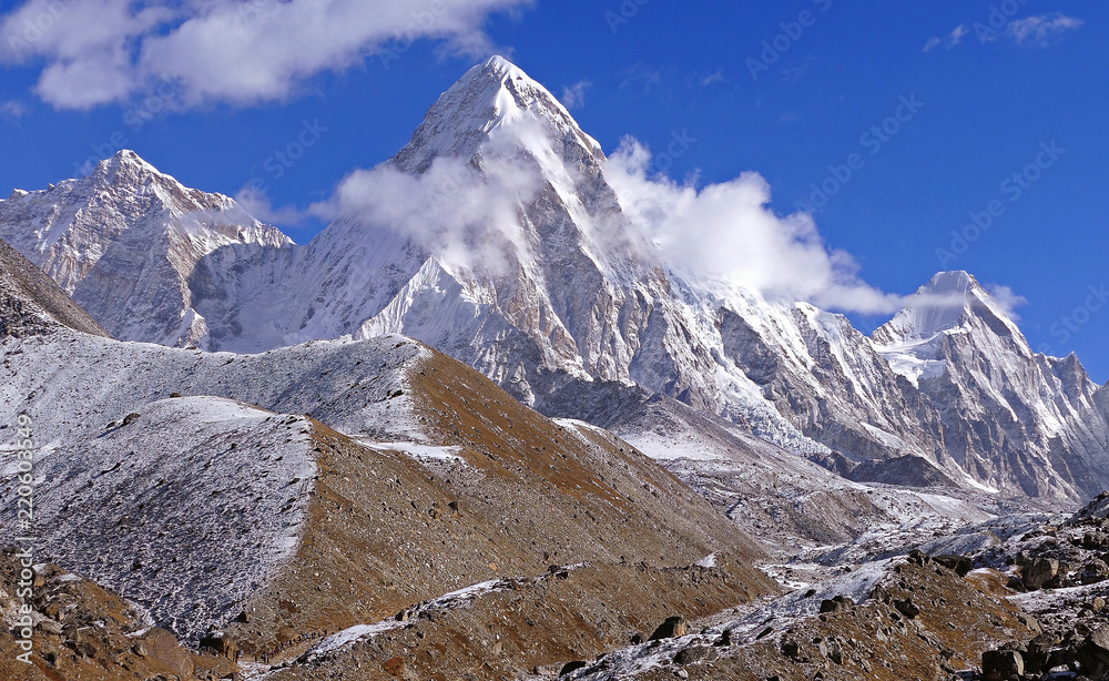 Obraz premium Activity, recreation: a group of tourists has a trekking towards the base camp of Everest peak (8848 m). Pumo Ri peak (7161 m), Nepal, Himalayas.