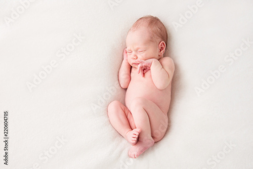 Funny newborn baby sleeping peacefully naked. Top view