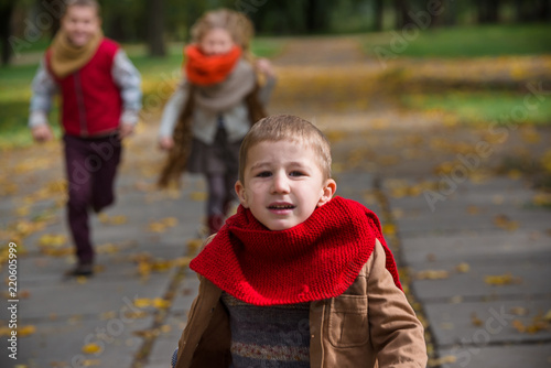 Fototapeta Naklejka Na Ścianę i Meble -  Happy children play and run in autumn park