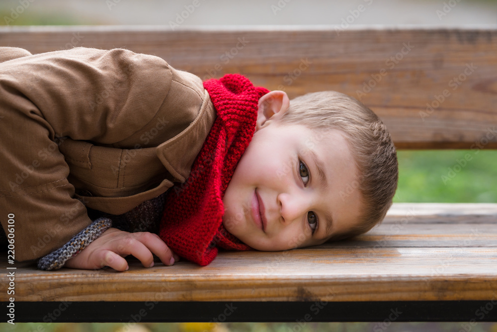 Little boy lays on wooden banch portrait Little boy lays on wooden banch portrait
