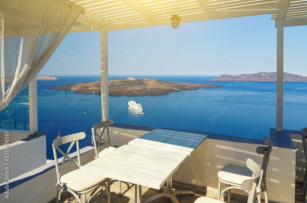 White architecture on Santorini island, Greece. Beautiful terrace with sea view of Caldera and cruise ship.