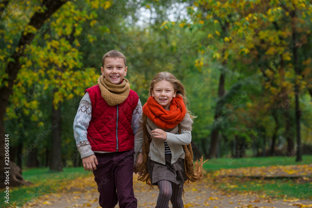 Happy children play and run in autumn park Happy children play and run in autumn park