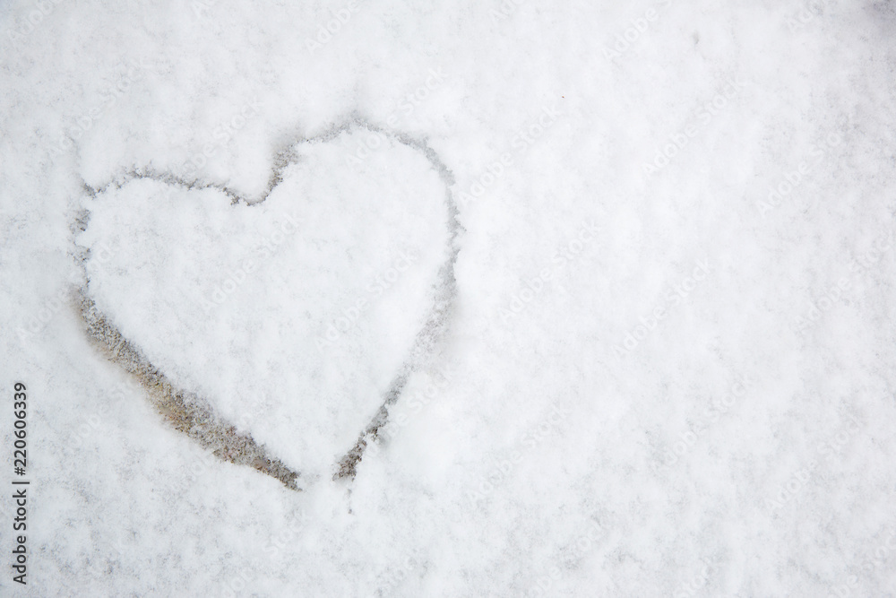 The symbol of the heart, painted on the fresh white snow.drawn heart in the snow.Image of the heart in the snow. The symbol of the heart, painted on the fresh white snow.drawn heart in the snow.Image of the heart in the snow.