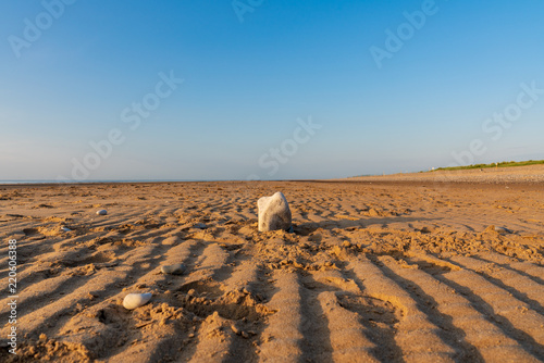A stone on an empty beach on the Welsh coast near Prestatyn  Denbighshire  Wales