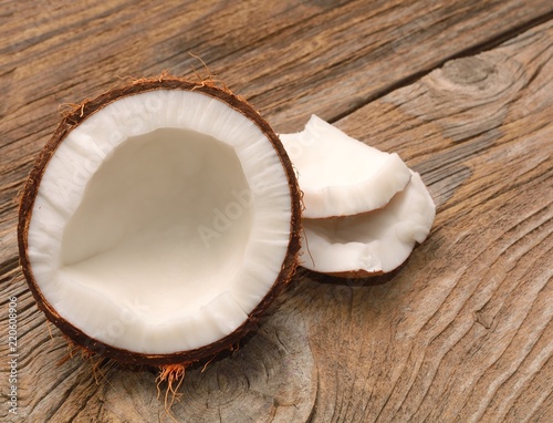 Coconut cut in half on wooden board