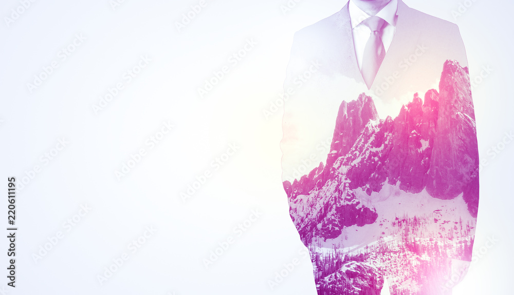  Young businessman in suit standing with sunny snowy mountain and trees graphic.