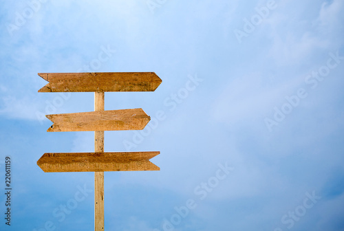 Empty signage isolated blue sky background. three way wooden sign isolated on sky © kanpisut