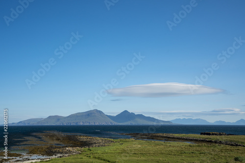 The island of Rum, with a lenticular cloud, as viewed from the Isle of Muck.  Rum, on the west coast of Scotland, is a National Nature Reserve, home to a diverse range of wildlife.