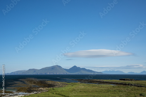 The island of Rum, with a lenticular cloud, as viewed from the Isle of Muck. Rum, on the west coast of Scotland, is a National Nature Reserve, home to a diverse range of wildlife.