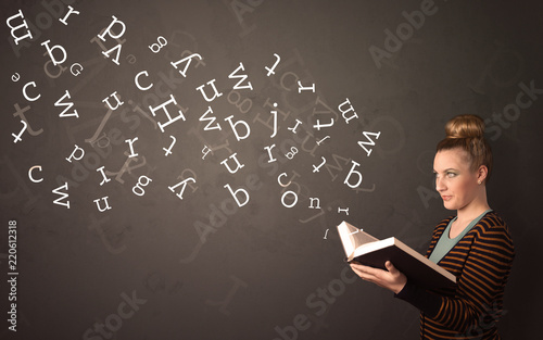 Casual young woman holding book with white alphabet flying out of it