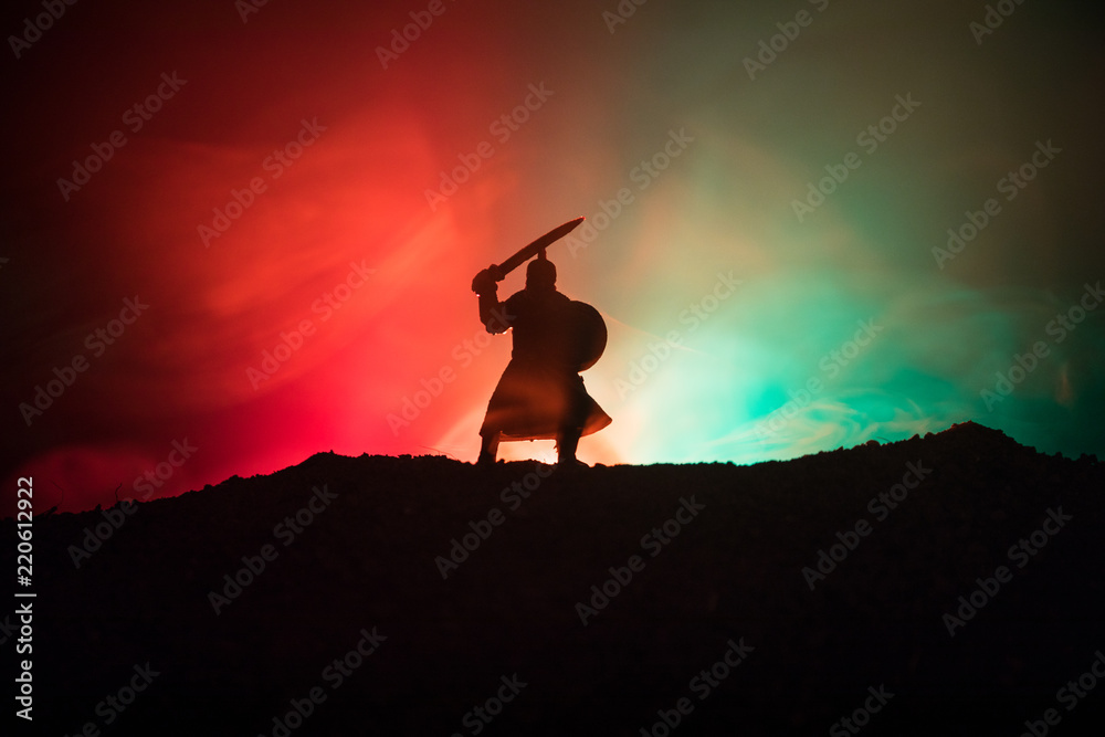 Fighter with a sword silhouette a sky. Medieval knight with sword. Selective focus