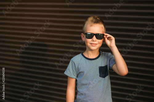 Handsome boy smiling and posing to the photographer. Boy have sunglasses