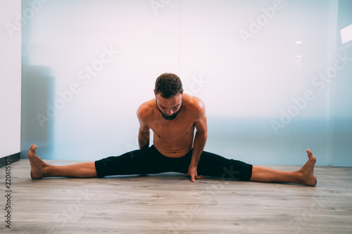 Yoga. Young man doing yoga exercise isolated on a white background. Yogi master workout on white urban studio. Yoga lifestyle healthy concept.