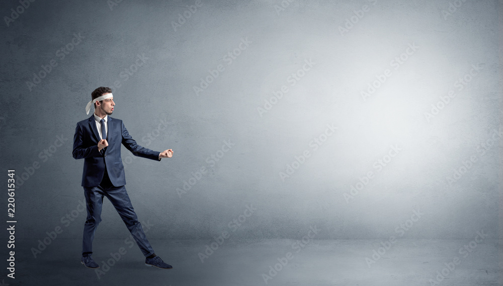 Small karate man fighting in an empty grey copy space Small karate man fighting in an empty grey copy space