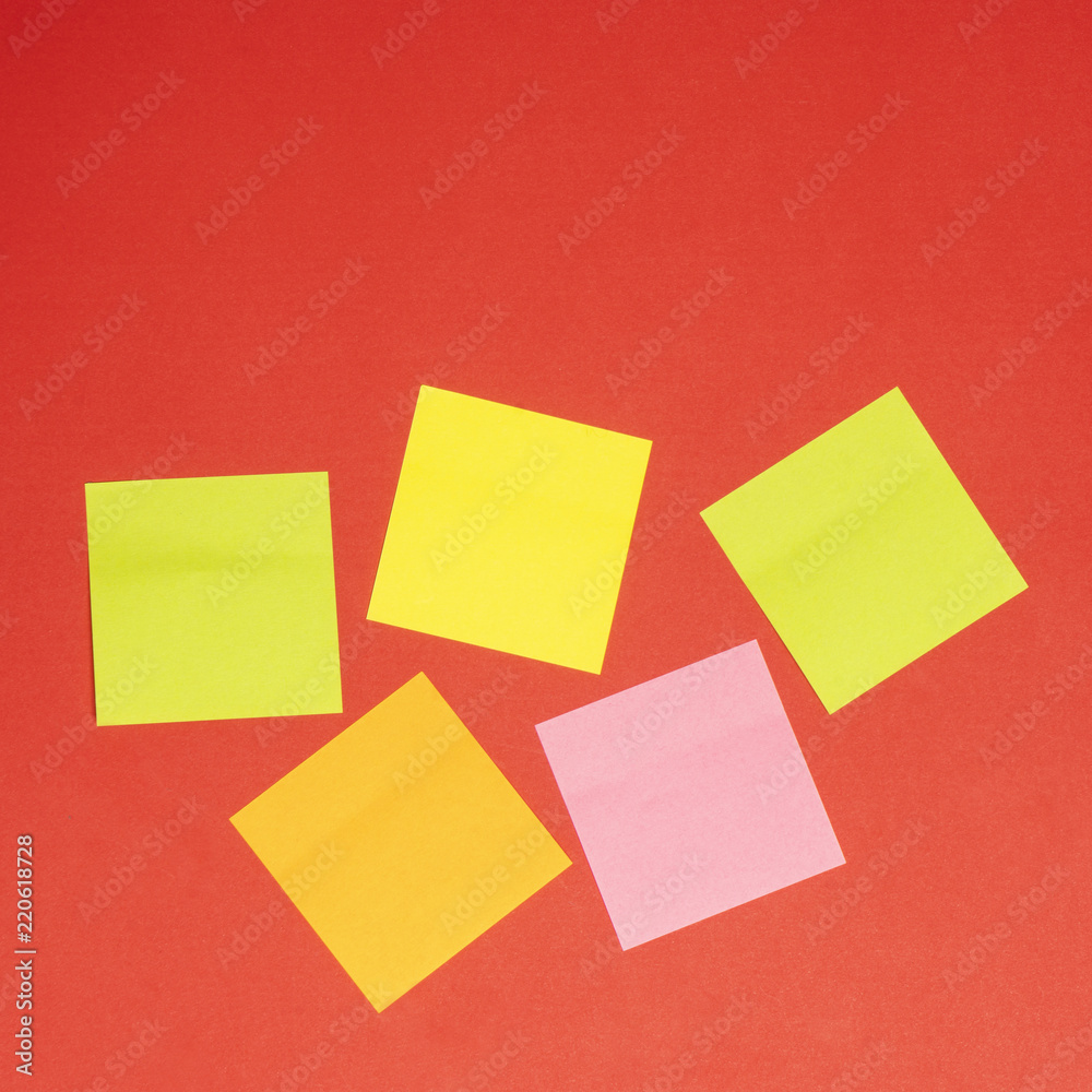some colored notepad on a red background some colored notepad on a red background