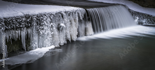 Kaskade an Flusslauf im Winter mit Eis und softem Wasser