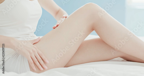 woman apply cream with leg