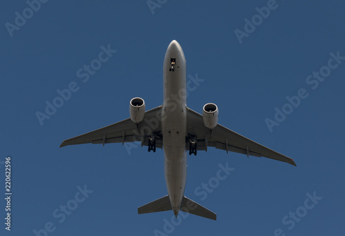  Passenger airplane flying on blue sky background is preparing to land
