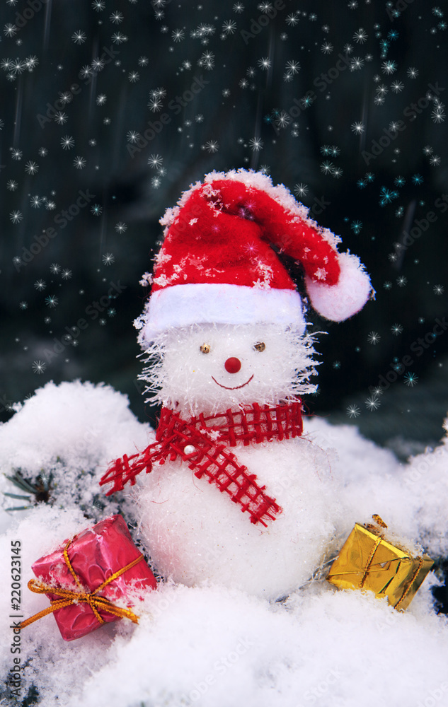 Snowman with Christmas gifts isolated on blue fir tree with white snow.
