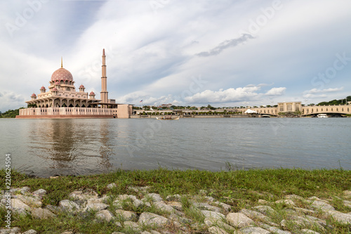 Pink color Putrajaya mosque surrounded by water at Putra Jaya city, the Malaysian Federal Territory administrative city framed with space for text messages