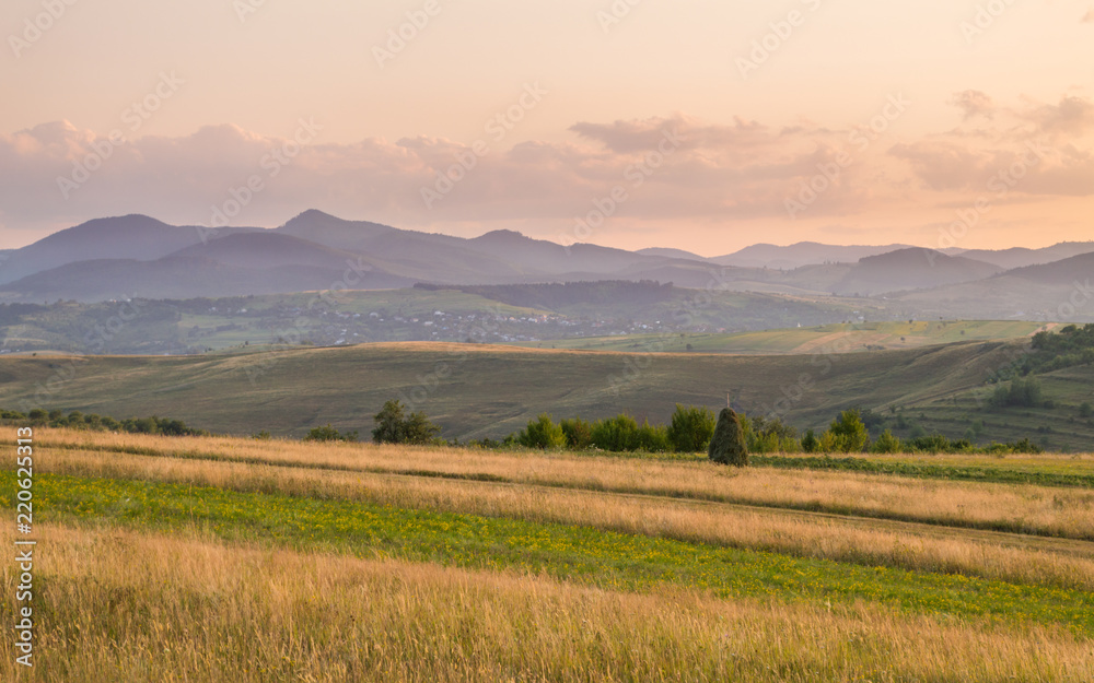 Meadow Hills and Mountains Landscape at Sunset