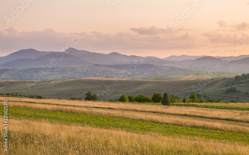 Meadow Hills and Mountains Landscape at Sunset