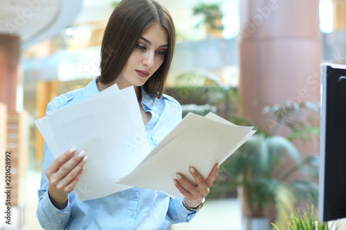 Concentrated business lady comparing documents at office. photo