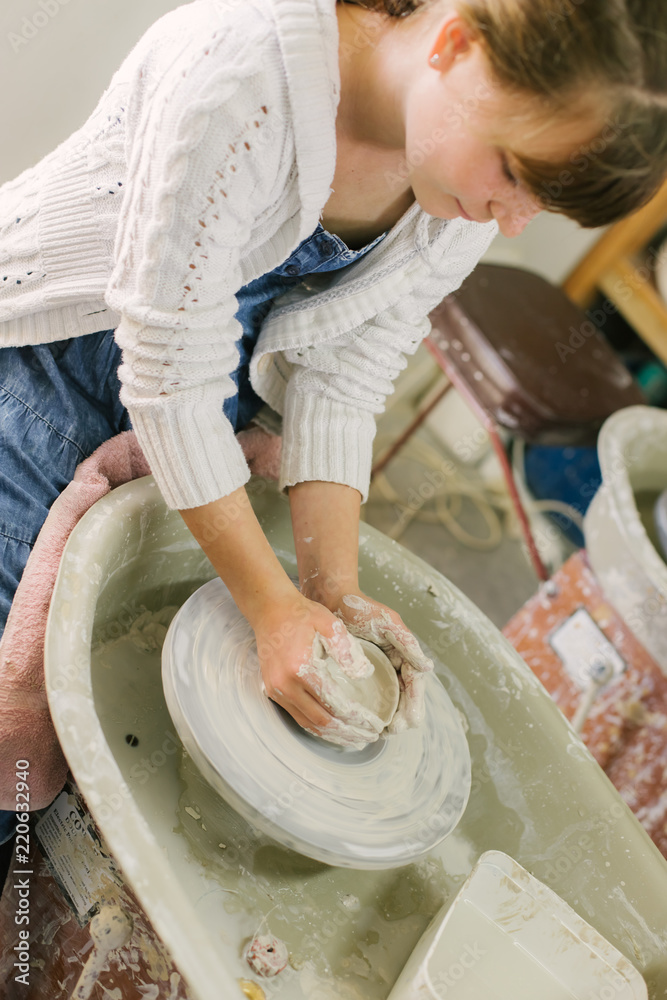working with clay on potter's wheel, closeup of hands, crafts and arts