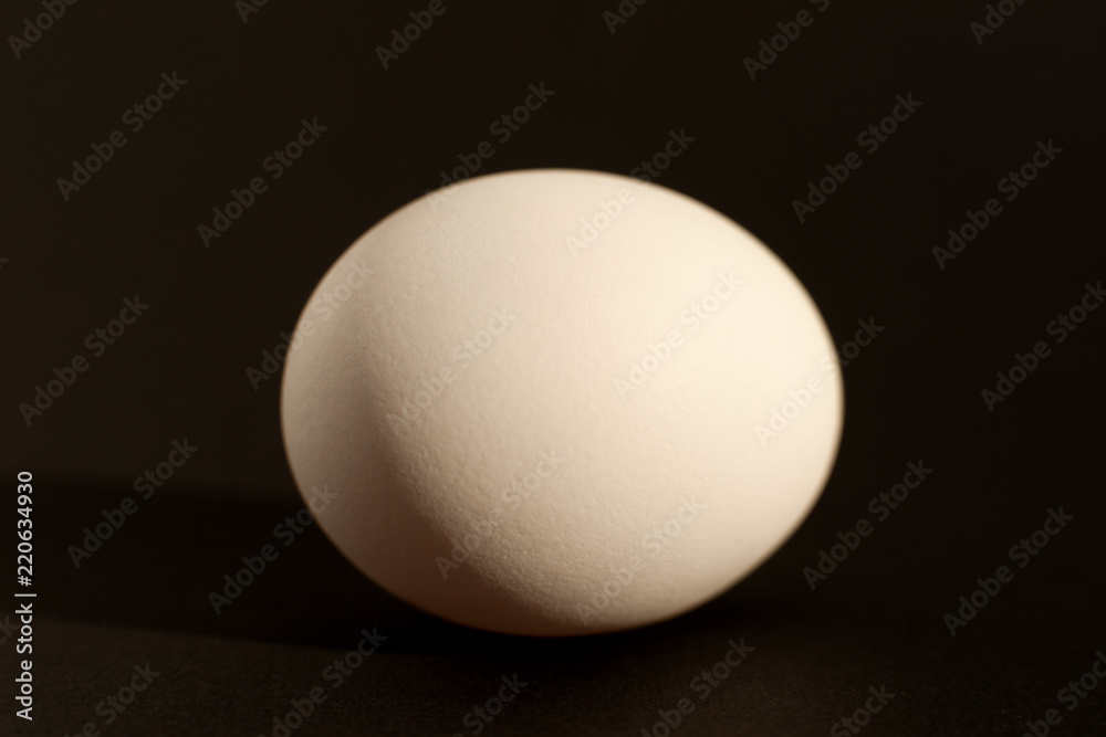 Egg on a black background. Macro. Chicken egg in the form of a sphere on a black background. Isolate. Chicken egg closeup. Egg on a black background. Macro. Chicken egg in the form of a sphere on a black background. Isolate. Chicken egg closeup.