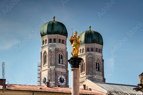 Two towers of Gothic Frauenkirche cathedral and Mariensaule statue, symbols of Bavarian capital, rise above roofs of Marienplatz square in Altstadt historic center of Munchen, Bayern Germany Europe