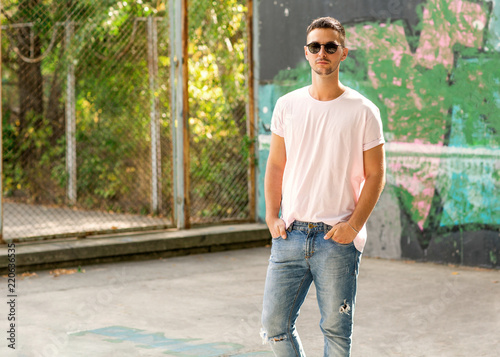 fashion guy posing outdoors in sunglasses