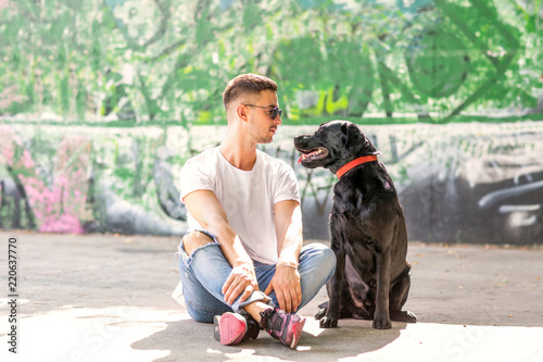 guy with a dog labrador on the street playing