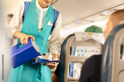 Canvas Print Flight attendant serving drinks to passengers on board.
