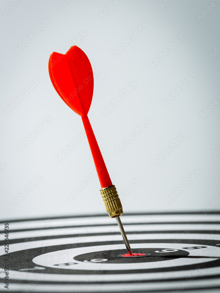 dart arrow hitting in the target center of dartboard. concept of the success