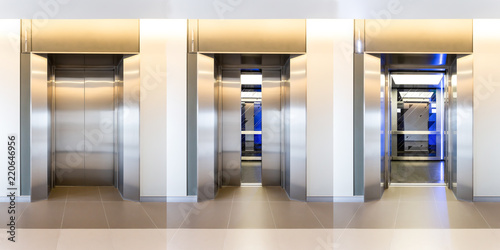 Modern steel elevator cabins in a business lobby or Hotel, Store, interior, office,perspective wide angle. Three elevators in hotel lobby.