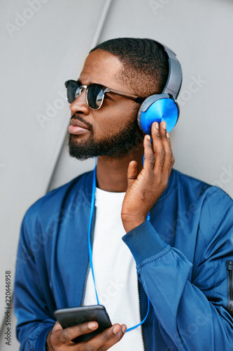 Listen Music. Man With Headphones And Phone In Fashion Clothes 