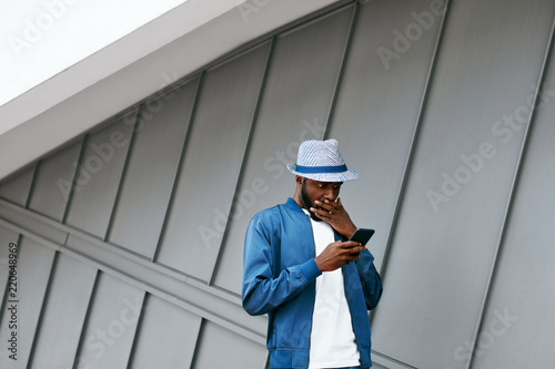 Handsome Black Man In Fashion Clothes With Phone On Street