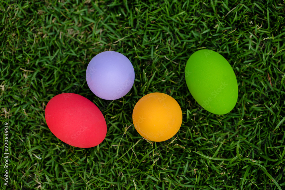Colorful Easter eggs background. holiday, easter background. Colorful easter eggs on the green garden yard. symbol of easter's day festival. vivid color natural background. festive wallpaper.
