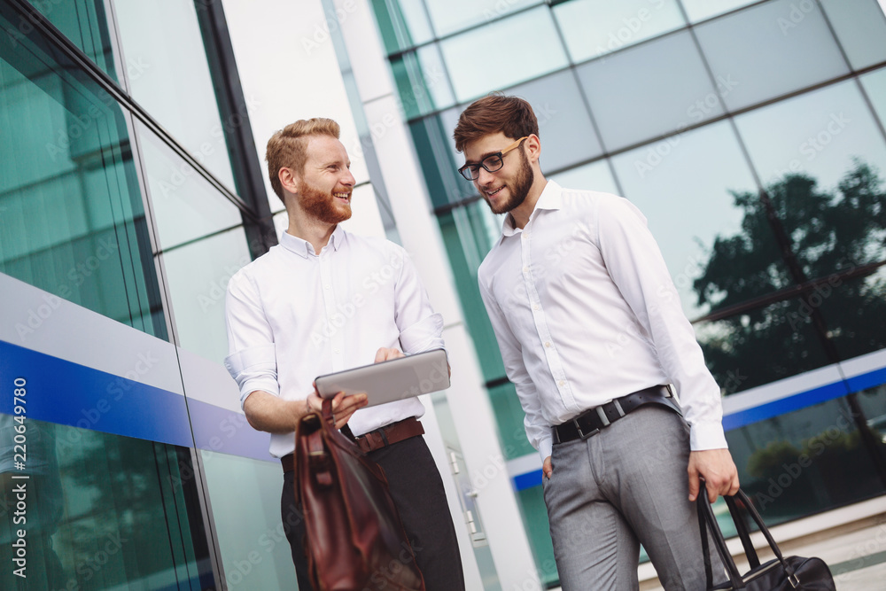 Businesspeople looking at tablet outdoors Businesspeople looking at tablet outdoors