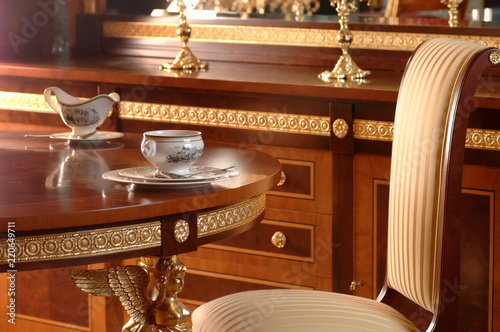 Fotografija tea-drinking at the table on the armchair and furniture made of wood with bronze