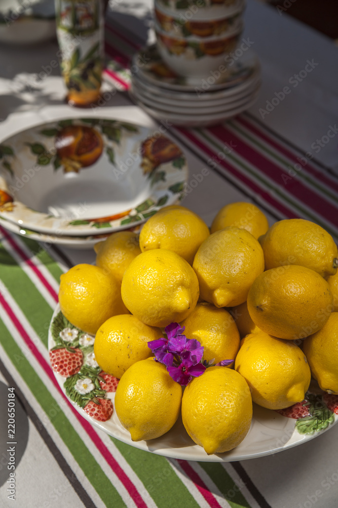 fresh homemade lemons on a plate on a table with striped tablecloth fresh homemade lemons on a plate on a table with striped tablecloth