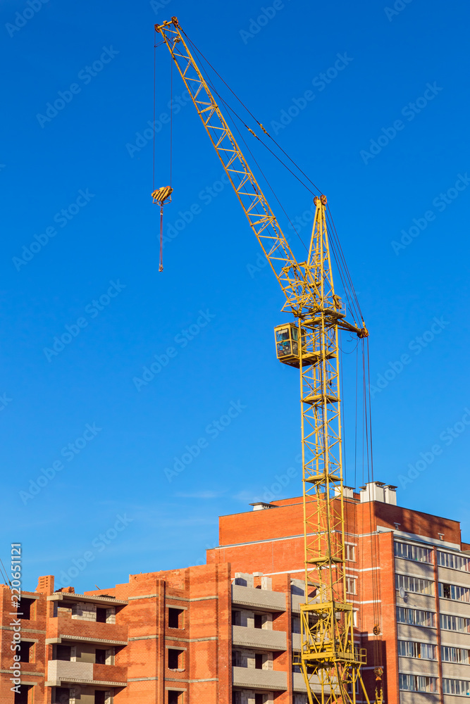 Construction of residential multi-storey houses with a crane in the foreground Construction of residential multi-storey houses with a crane in the foreground