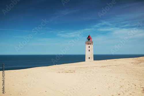 White beach sand dunes at the north danish coastline in summer sun light and blue sky. Rubjerg Knude Lighthouse, Lønstrup in North Jutland in Denmark, Skagerrak, North Sea