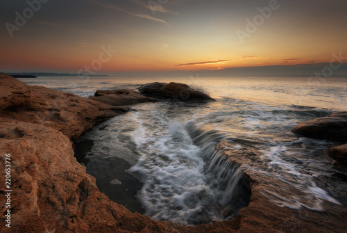 Seascape during sunrise. Beautiful natural seascape, blue hour. Sea sunrise at the Black Sea coast. Magnificent sunrise with clouds and fire sun in the middle of December.Ravda, Bulgaria