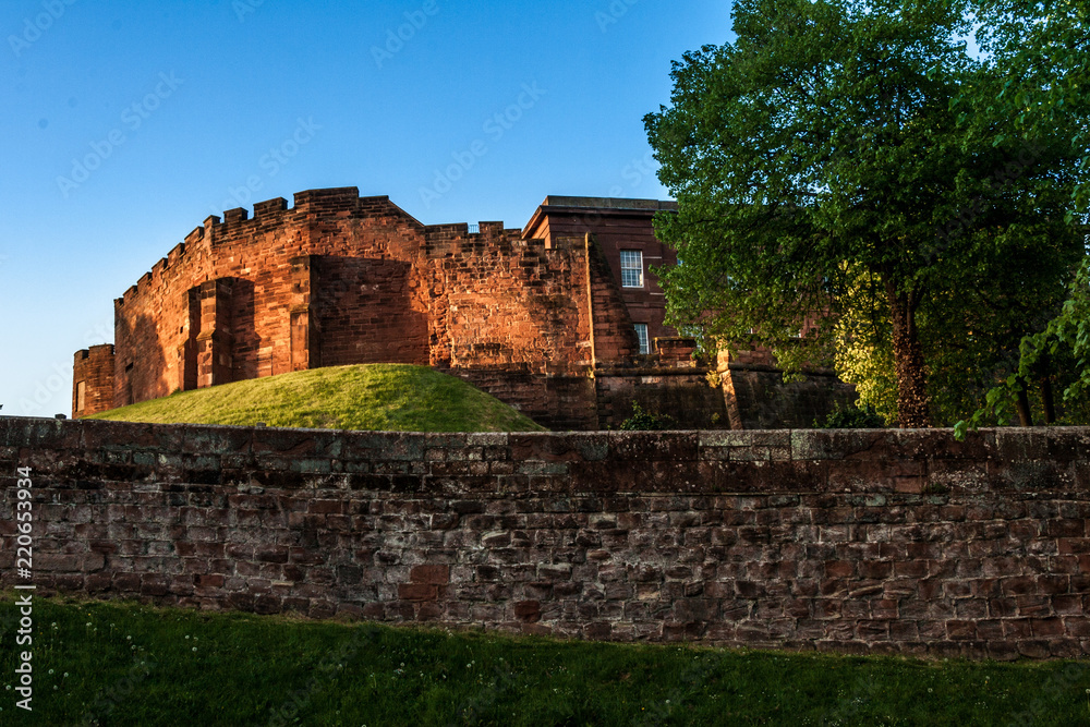 Chester medieval Castle at sunset, beyond the city wall. The castle and the walls are one of the major tourist attraction of the City of Chester. Chester medieval Castle at sunset, beyond the city wall. The castle and the walls are one of the major tourist attraction of the City of Chester.