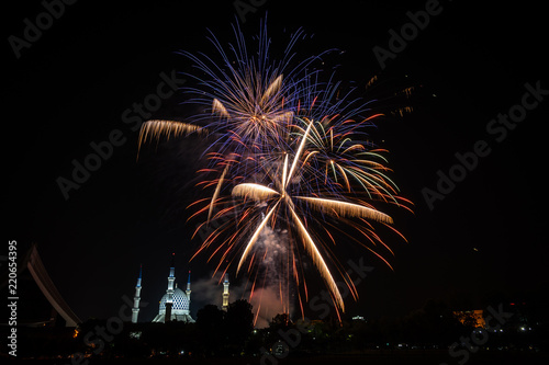 Fireworks during independence day celebration, with a mosque in the background