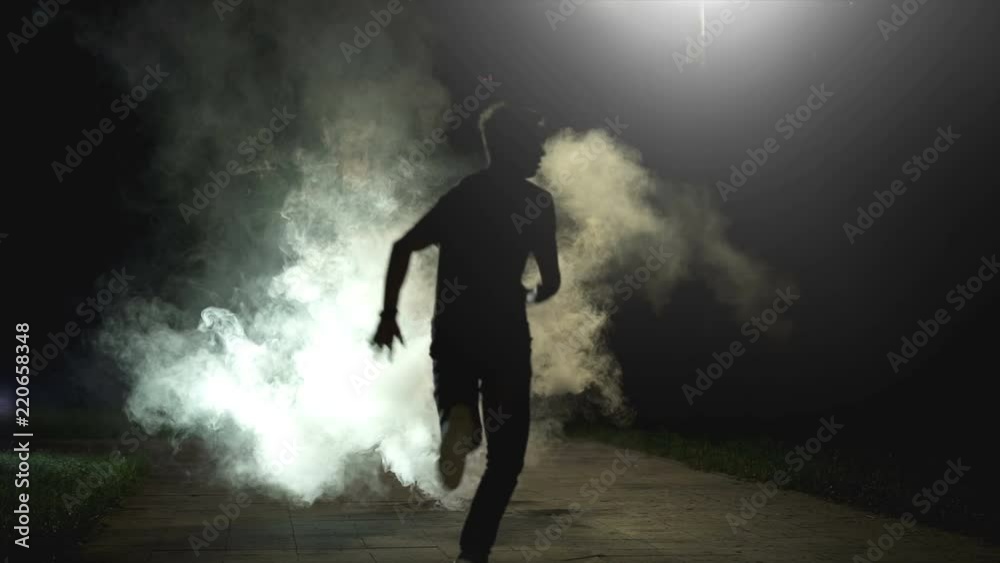 The fellow running in the cloud of smoke on the dark background, slow motion